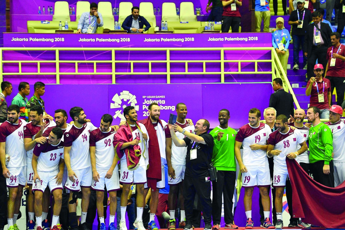 Qatari handball team members and officials celebrate on the podium after winning the gold medal, defeating Bahrain 32-27 in the final during the 2018 Asian Games in Jakarta yesterday.  