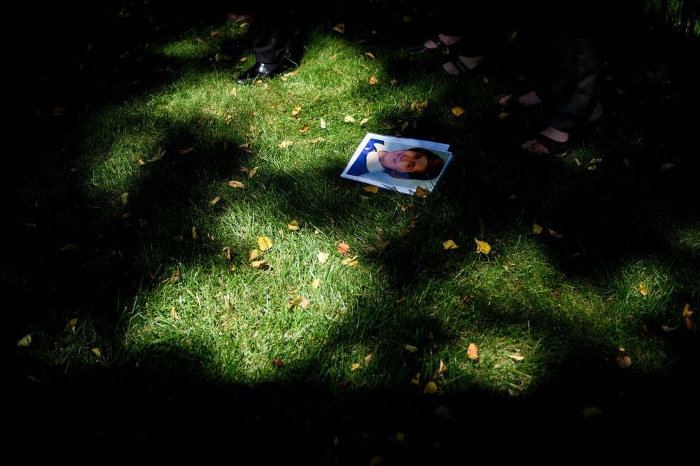 A photo of Barbara Blaine, a sexual abuse victim, is seen on the ground as activists hold a press conference outside the Vatican's US embassy about sexual abuse in the Catholic Church on August 30, 2018 in Washington, DC.  AFP / Brendan Smialowski 