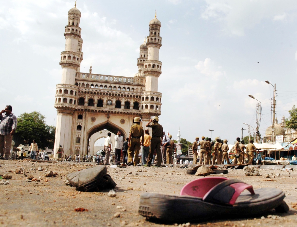 (FILES) In this file photo taken on May 18, 2007 police and members of the media walk around the Char Minar gate in Hyderabad, following a deadly blast at the nearby Macca Masjid mosque. AFP / Noah Seelam 