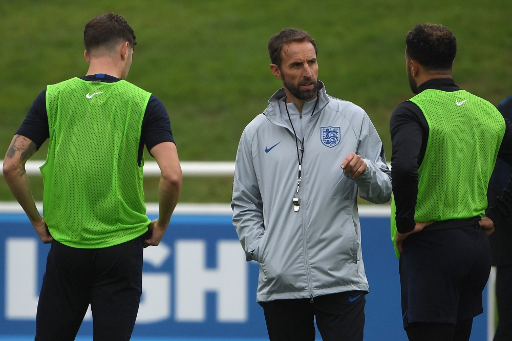 England's manager Gareth Southgate (C) talks to England's defender John Stones (L) and England's defender Kyle Walker during an open training session at St George's Park in Burton-on-Trent, central England on September 4, 2018, ahead of their internationa