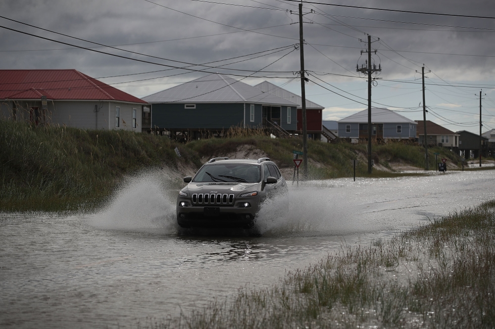 A vehicle drives along a flooded street caused by the approaching Tropical Storm Gordon on September 4, 2018 in Dauphin Island, Alabama. Joe Raedle/Getty Images/AFP
