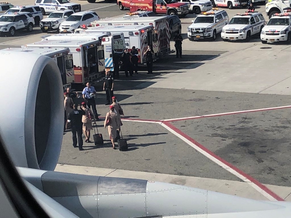 Air cabin crew members and the emergency services are seen leaving the plane, after the passengers were taken ill on a flight from New York to Dubai, on JFK Airport, New York, U.S., September 05, 2018 in this still image obtained from social media. Larry 