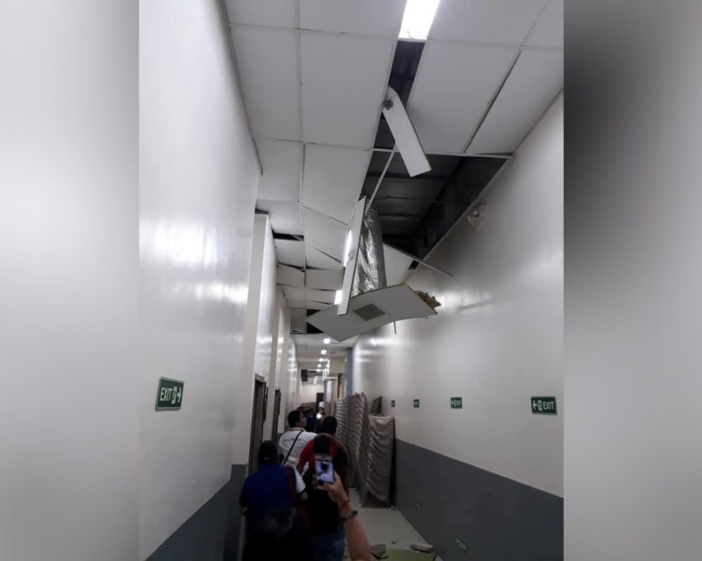 People exit through a hallway damaged by an earthquake in Davao City, Mindanao, Philippines September 8, 2018. GARDO DAGONDON/ REUTERS 
