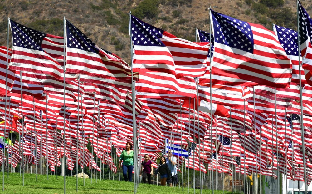 A family visitS the 'Waves of Flags' display at Pepperdine University in Malibu, California on September 10, 2018, where the annual display of 2,997 flags commemorates victims of the September 11, 2001 terrorist attacks. / AFP / Frederic J. BROWN 