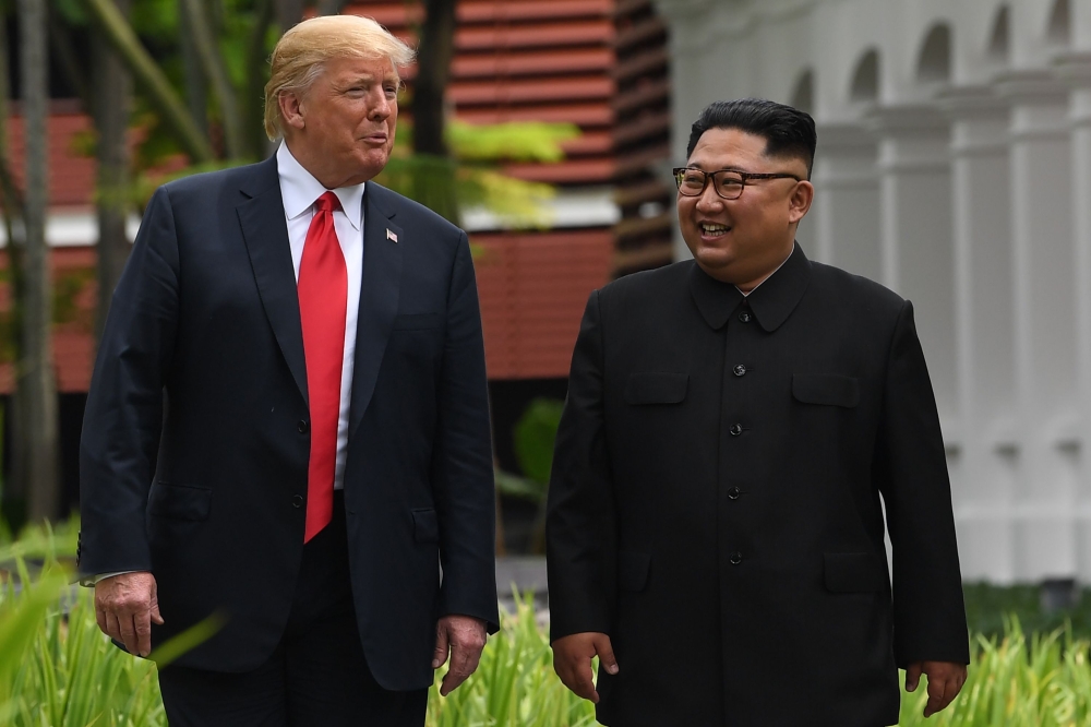 In this file photo taken on June 11, 2018 North Korea's leader Kim Jong Un (R) walks with US President Donald Trump (L) during a break in talks at their historic US-North Korea summit, at the Capella Hotel on Sentosa island in Singapore.  / AFP / SAUL LOE