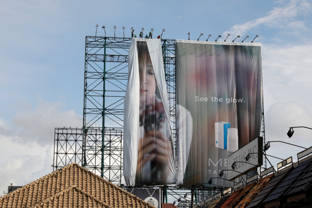 Workers roll advertising billboards along main road EDSA in preparation for the coming of Super Typhoon Mangkhut before it hits the main island of Luzon, in Quezon City, Metro Manila, Philippines, September 12, 2018. REUTERS/Erik De Castro