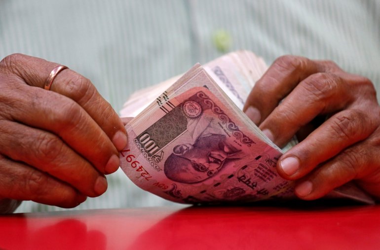 A man counts Indian currency notes inside a shop in Mumbai, India, August 13, 2018. Reuters/Francis Mascarenhas
