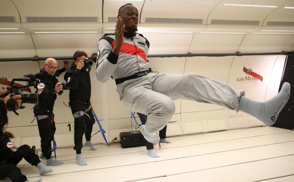 This handout photo released by Mumm/Novespace on September 13, 2018 shows Jamaican retired sprinter Usain Bolt (C) gesturing in zero-gravity conditions in an aircraft on September 12, 2018 above Reims.  AFP  / Mumm/Novespace/Laurent Theillet