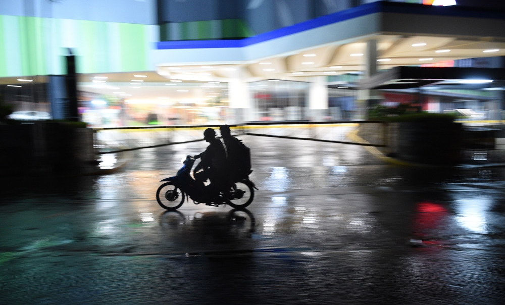 Motorists speed past a deserted street and shopping mall as Typhoon Mangkhut approaches the city of Tuguegarao, Cagayan province, north of Manila on September 14, 2018.  AFP / Ted Aljibe 