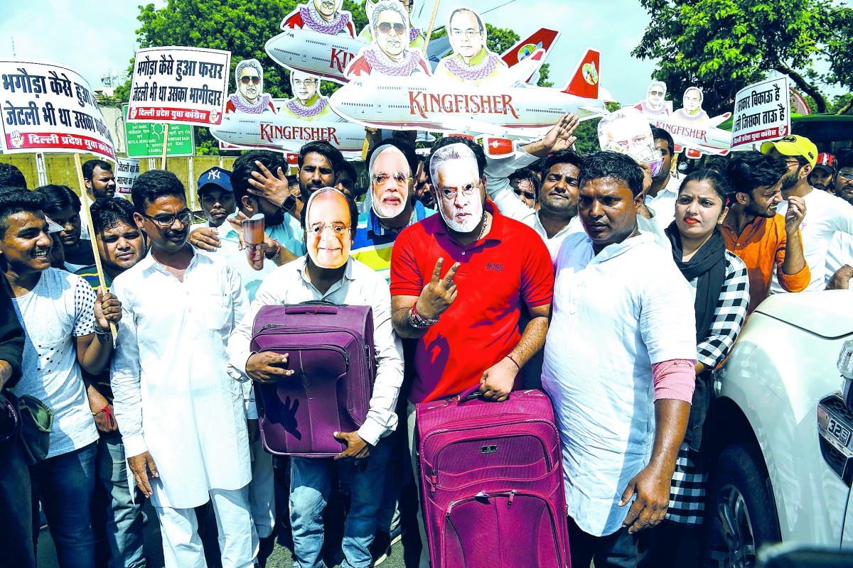 Activists and supporters of the Indian Youth Congress wear masks bearing images of Finance Minister Arun Jaitley (L), businessman Vijay Mallya and Prime Minister Narendra Modi (C) as they protest against the Bharatiya Janata Party (BJP) for allegedly allo