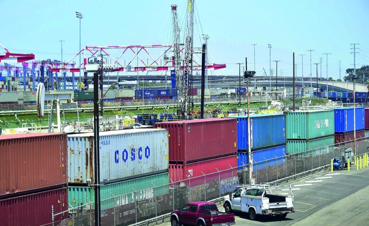 In this file photo taken on July 12, 2018 shipping containers, including those from COSCO, a Chinese state-owned shipping and logistics company await transportation on a rail line at the Port of Long Beach in Long Beach, California.  AFP / Frederic J BROW