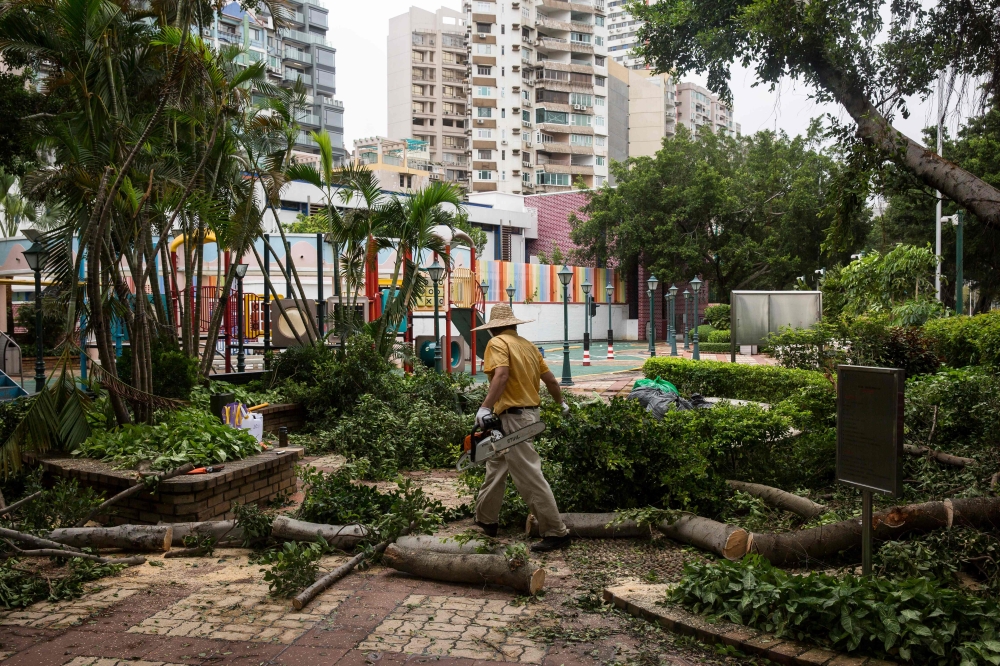 A worker clears branches from a playground a day after Typhoon Mangkhut hit Macau on September 17, 2018. / AFP / ISAAC LAWRENCE