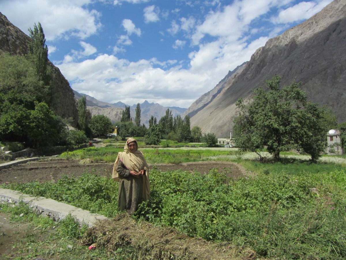 A resident of Siksa, Pakistan, stands near crops irrigated with water from a new pipeline and storage tank system serving the village, September 4, 2018. Thomson Reuters Foundation/Rina Saeed Khan