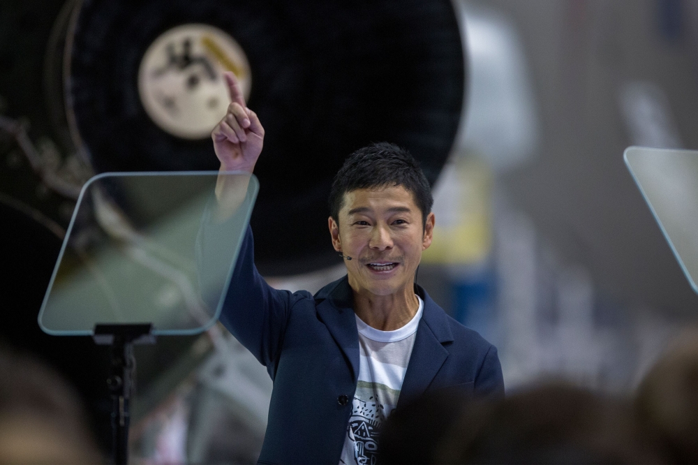 Japanese billionaire Yusaku Maezawa reacts near a Falcon 9 rocket during the announcement by Elon Musk to be the first private passenger who will fly around the Moon aboard the SpaceX BFR launch vehicle, at the SpaceX headquarters and rocket factory on Se