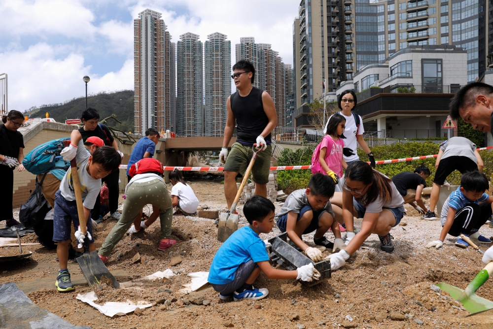Volunteers clear a damaged path after Super Typhoon Mangkhut hit Hong Kong, China September 18, 2018. REUTERS/Tyrone Siu	
