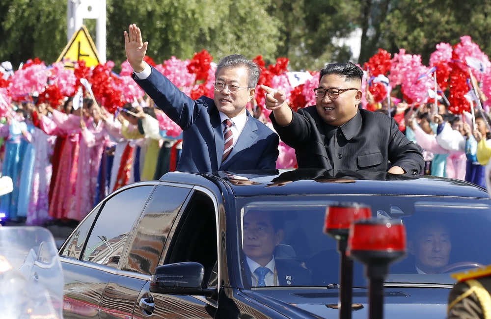 North Korean leader Kim Jong Un (R) and South Korean President Moon Jae-in (L) wave to Pyongyang citizens from an open-topped as they drive through Pyongyang on September 18, 2018. AFP PHOTO / Pyeongyang Press Corps