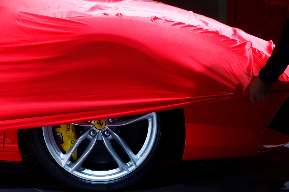 FILE PHOTO: A partially covered Ferrari car is pictured before the opening of the Frankfurt Motor Show (IAA) in Frankfurt, Germany, September 11, 2017. REUTERS/Kai Pfaffenbach