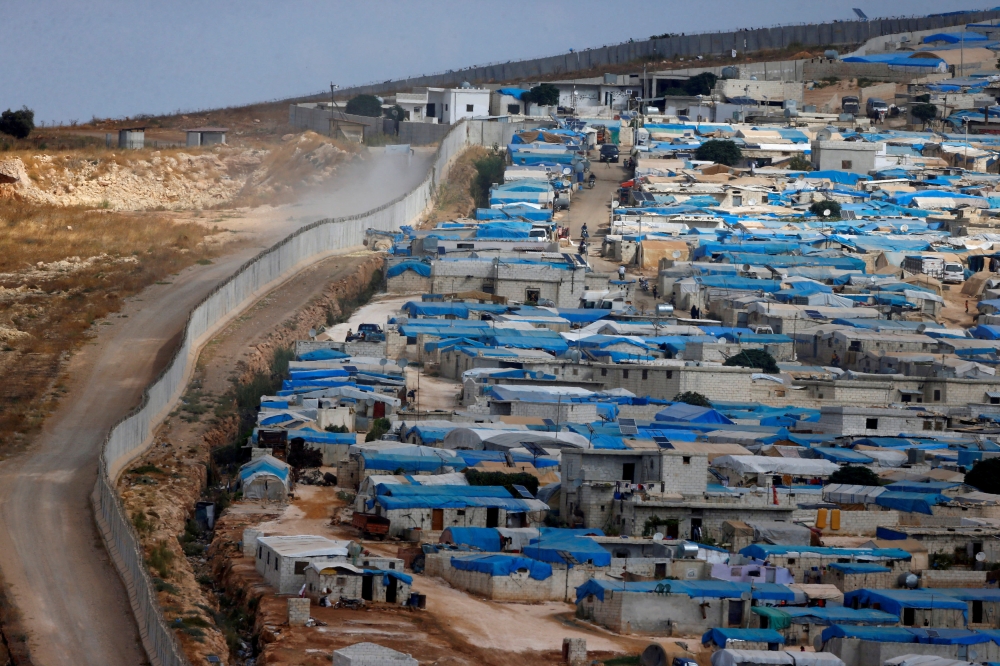 FILE PHOTO: A wall along the border between Turkey and Syria is pictured at the Syrian town of Atimah, Idlib province, in this picture taken from Reyhanli, Hatay province, Turkey October 10, 2017. REUTERS/Osman Orsal
