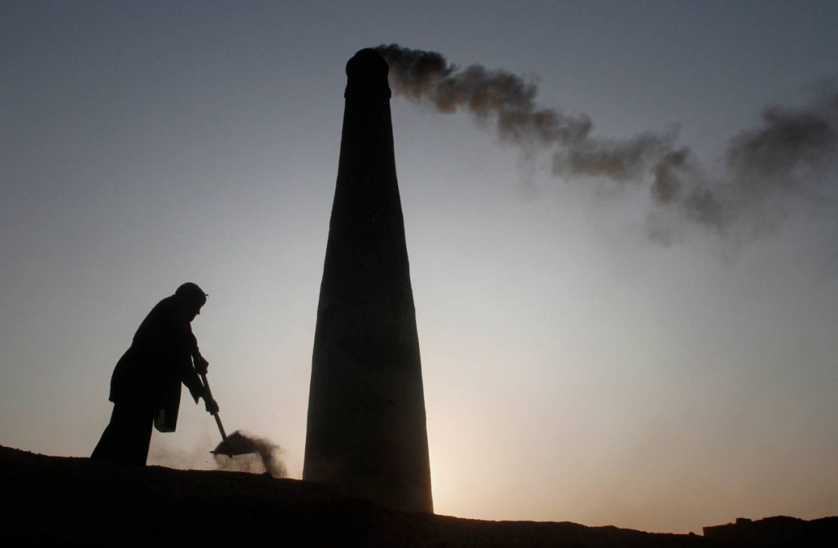 A man removes dirt from an oven to retrieve baked bricks at a brickyard in the outskirts of Islamabad December 28, 2011. Reuters/Faisal Mahmood 