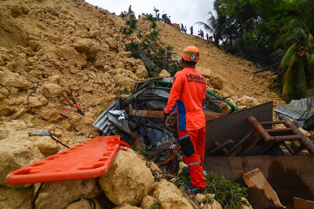 Rescuers search for survivors at a landslide site in Naga City, on the popular tourist island of Cebu on September 20, 2018.  AFP / ALAN TANGCAWAN
