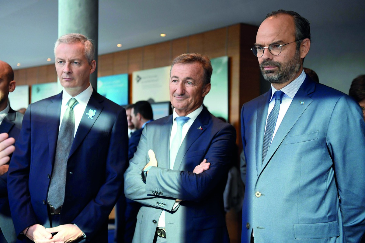 French Prime Minister Edouard Philippe (R) and French Economy Minister Bruno Le Maire (L) listen to general director of Dassault System Bernard Charles as they visit the group's headquarters prior to a press conference on the theme 