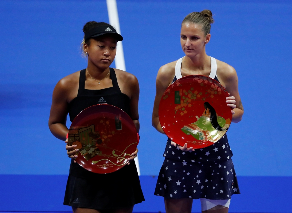 Karolina Pliskova (R) of Czech Republic, flanked by second-placed Naomi Osaka of Japan, poses with her victory trophy. REUTERS/Toru Hanai