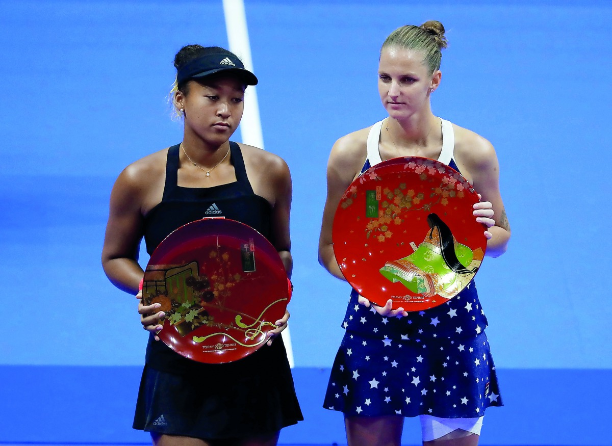 Karolina Pliskova (R) of Czech Republic, flanked by second-placed Naomi Osaka of Japan, poses with her victory trophy. Reuters/Toru Hanai 