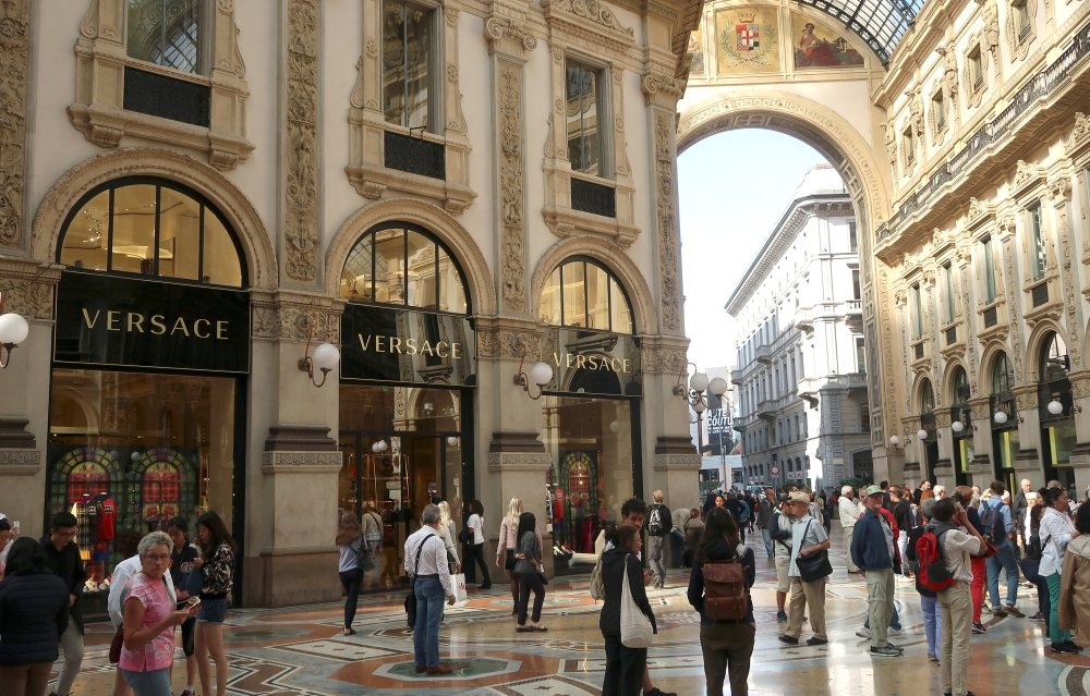 People stroll in front of Versace's flagship shop at Galleria Vittorio Emanuele II in Milan, Italy, September 25, 2018. Reuters/Stefano Rellandini
