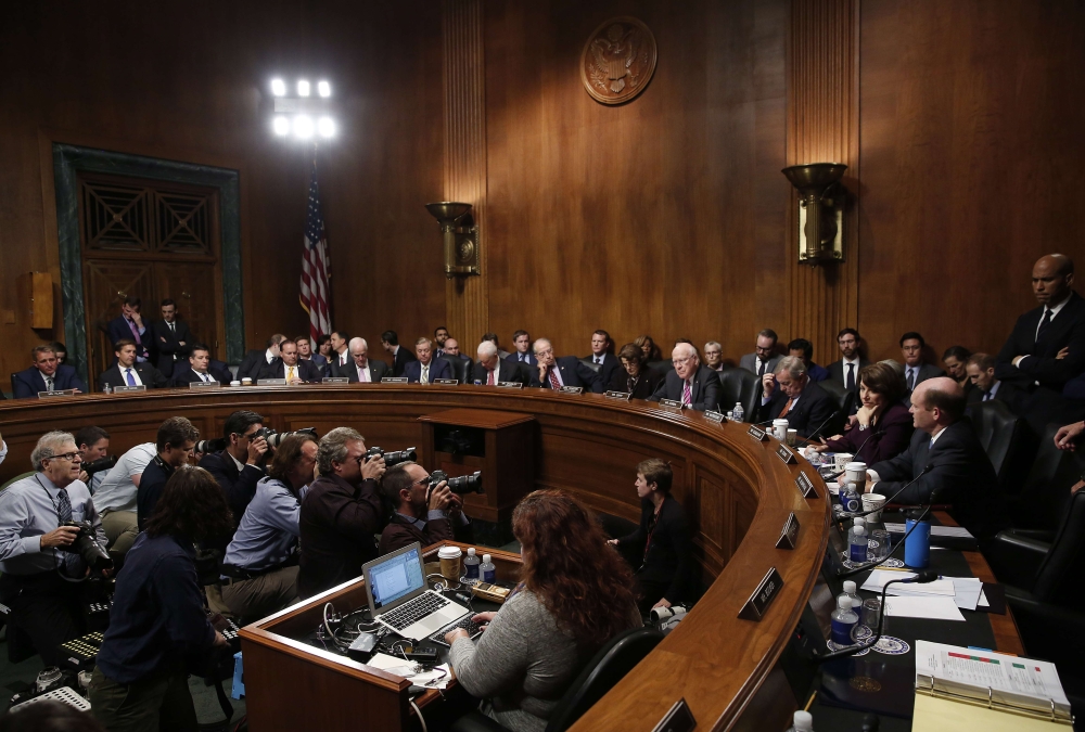 Members of the Senate Judiciary Committee listen as Sen. Jeff Flake (L) (R-AZ) speaks with Sen. Chris Coons (D-DE) after Flake announced he is in favor of additional time in the Kavanaugh investigation September 28, 2018 in Washington, DC. Win McNamee/Get