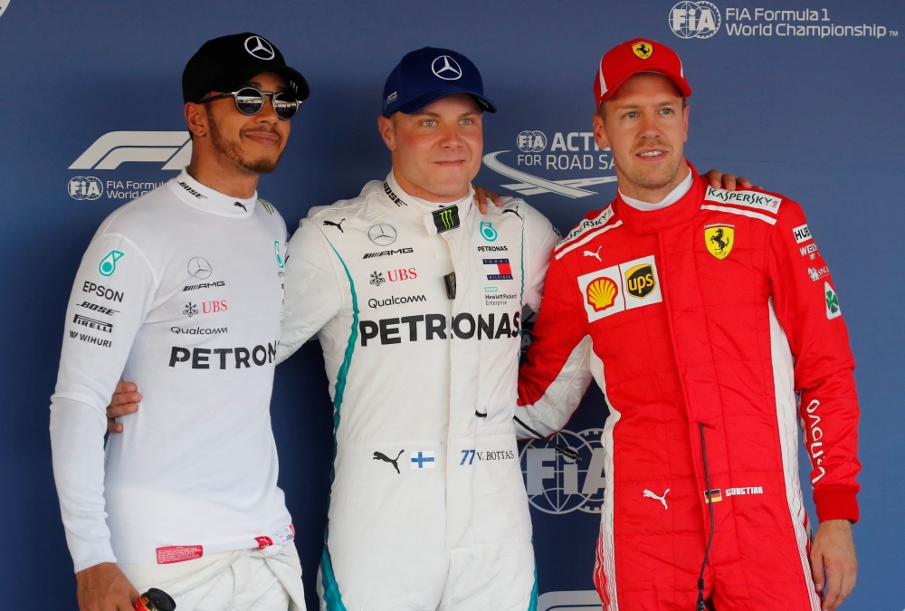 Mercedes' Valtteri Bottas (C) after qualifying in pole position with teammate Lewis Hamilton (L), who qualified second and Ferrari's Sebastian Vettel, who qualified third REUTERS/Maxim Shemetov