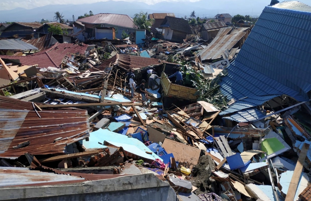 People search through debris in a residential area following an earthquake and tsunami in Palu, Central Sulawesi, Indonesia September 30, 2018 in this photo taken by Antara Foto. Antara Foto/Darwin Fatir/via REUTERS 