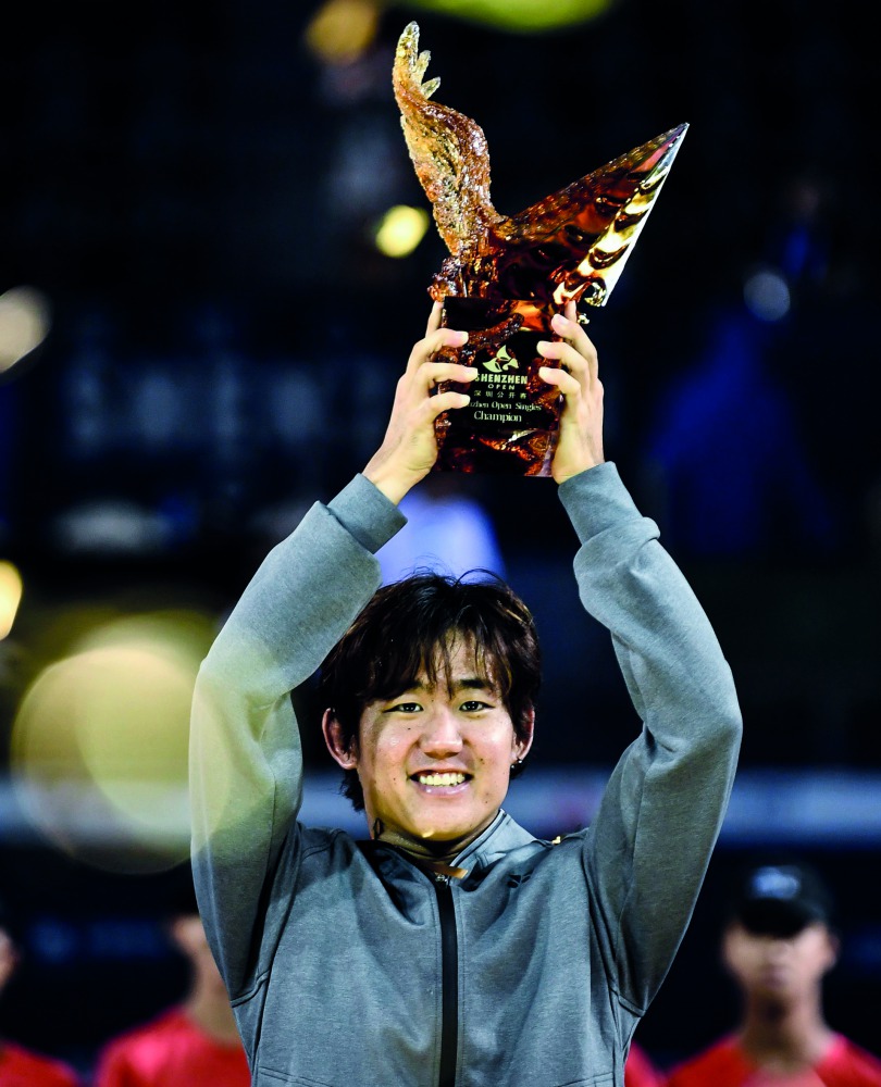 Yoshihito Nishioka of Japan celebrates with the trophy after winning the men's singles final against Pierre-Hugues Herbert of France at the ATP Shenzhen Open tennis tournament in Shenzhen, in south China's Guangdong province on September 30, 2018. AFP