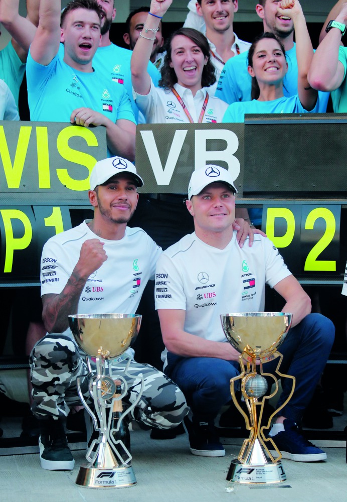 Second placed Mercedes' Valtteri Bottas and first placed Mercedes' Lewis Hamilton celebrate with their trophies after the race. Reuters/Maxim Shemetov 
