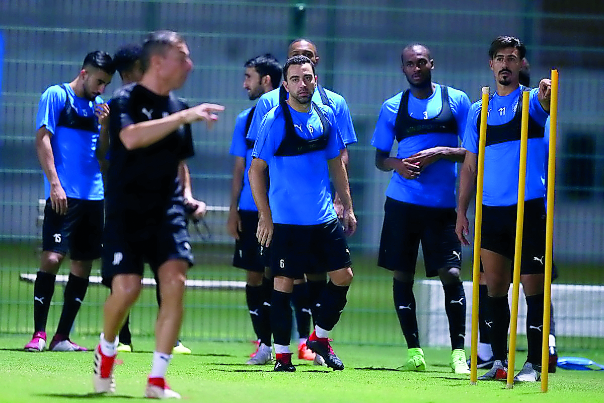 Al Sadd captain Xavi (centre), winger Abdulkarem Hasan (second right) and striker Baghdad Bounedjah (right) during a team's training session, in this file photo.     