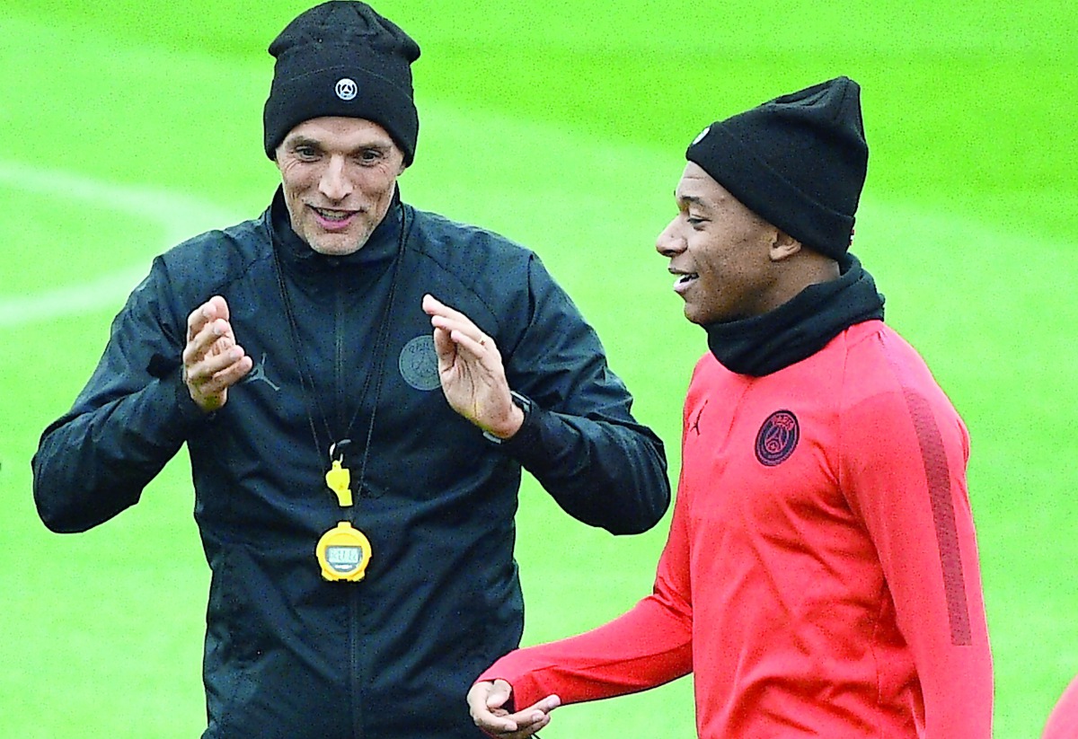 aris Saint-Germain's German coach Thomas Tuchel (L) speaks with Paris Saint-Germain's French forward Kylian Mbappe (R) during a training session on the eve of the team's Champions League football match against Belgrad (Crvena zvezda) on October 2, 2018 at