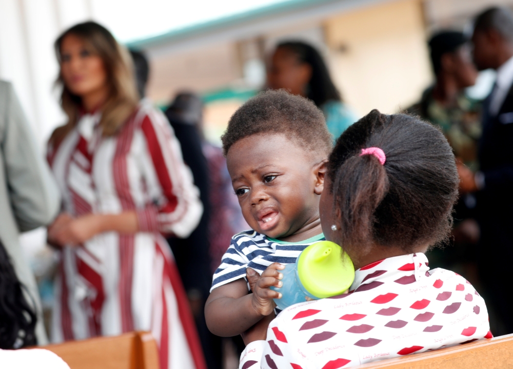A woman holds a child as U.S. first lady Melania Trump visits a hospital in Accra, Ghana, October 2, 2018. REUTERS/Carlo Allegri
