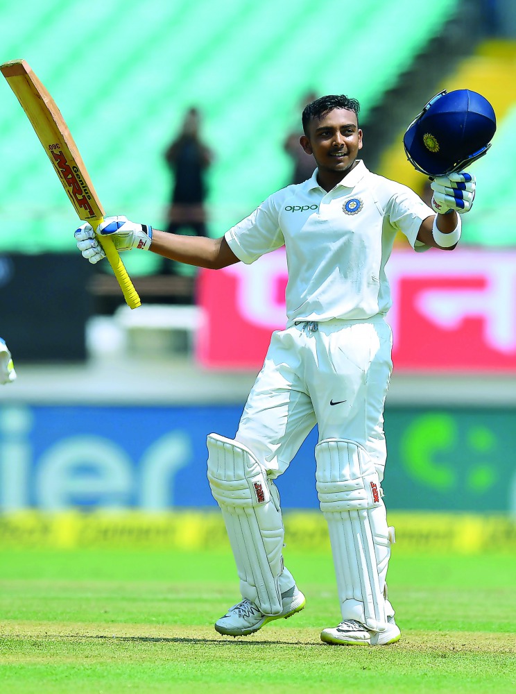 Prithvi Shaw celebrates after scoring a century (100 runs) during the first of the first Test cricket match between India and West Indies at the Saurashtra Cricket Association stadium in Rajkot on October 4, 2018. AFP / Indranil Mukherjee 