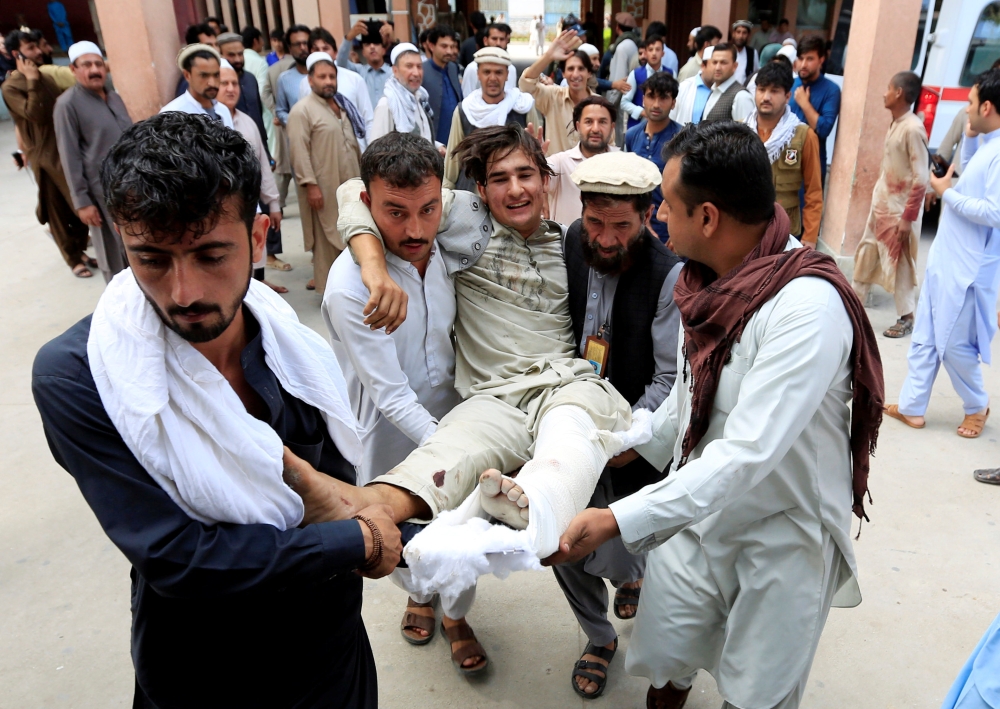 Afghan men carry an injured man to a hospital after a suicide attack, in Jalalabad, Afghanistan October 2, 2018. REUTERS/Parwiz