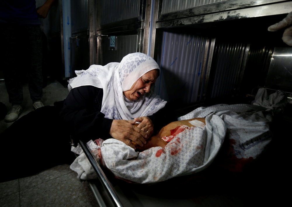 A relative reacts at the body of a Palestinian who was killed during a protest at the Israel-Gaza border fence, in Gaza City October 5, 2018. Reuters/Mohammed Salem 