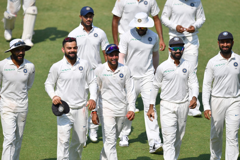 (front L-R) Indian cricketers Ravindra Jadeja, Virat Kohli, Kuldeep Yadav, Ajinkya Rahane and Cheteshwar Pujara walk back after winning the first Test cricket match between India and West Indies at the Saurashtra Cricket Association Stadium in Rajkot on O