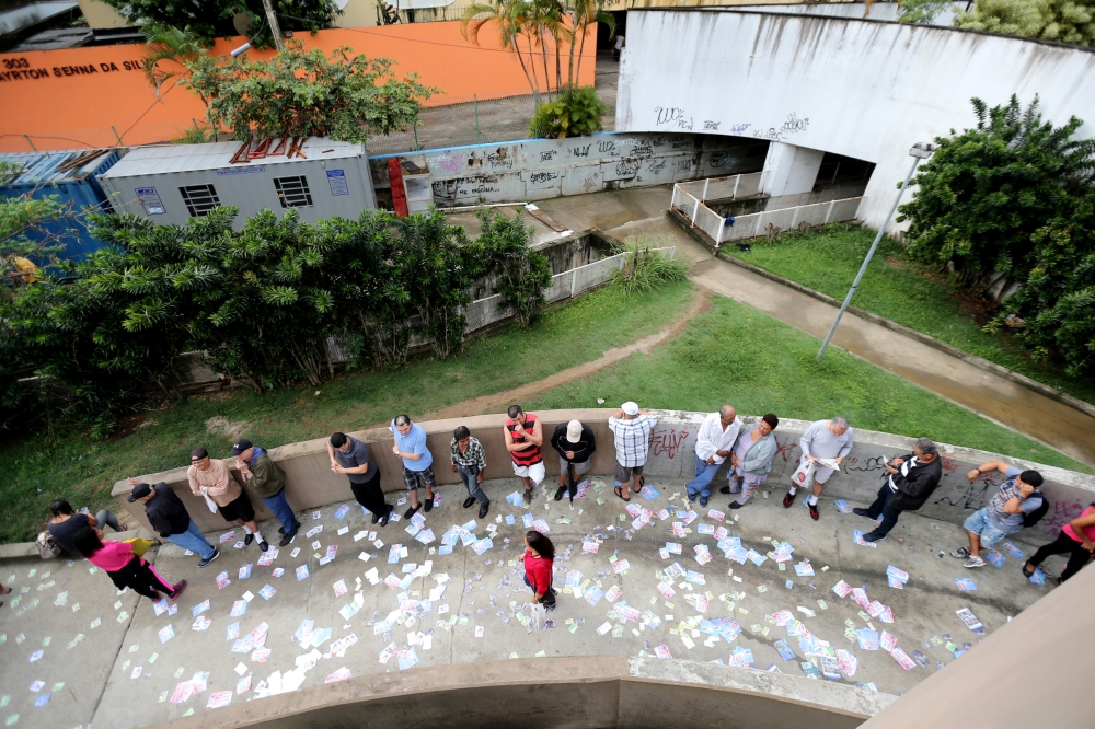 Brazilians stand in line outside a polling station to cast their votes in the presidential election, in Rio de Janeiro, Brazil October 7, 2018. REUTERS/Sergio Moraes