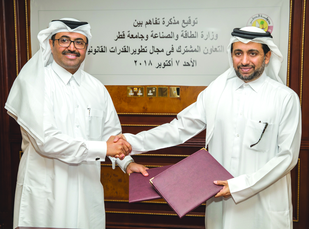 H E Dr Mohammed bin Saleh Al Sada (left), Minister of Energy and Industry, shakes hand with Dr Hassan bin Rashid Al Derham, Qatar University President, after signing the MoU yesterday. 