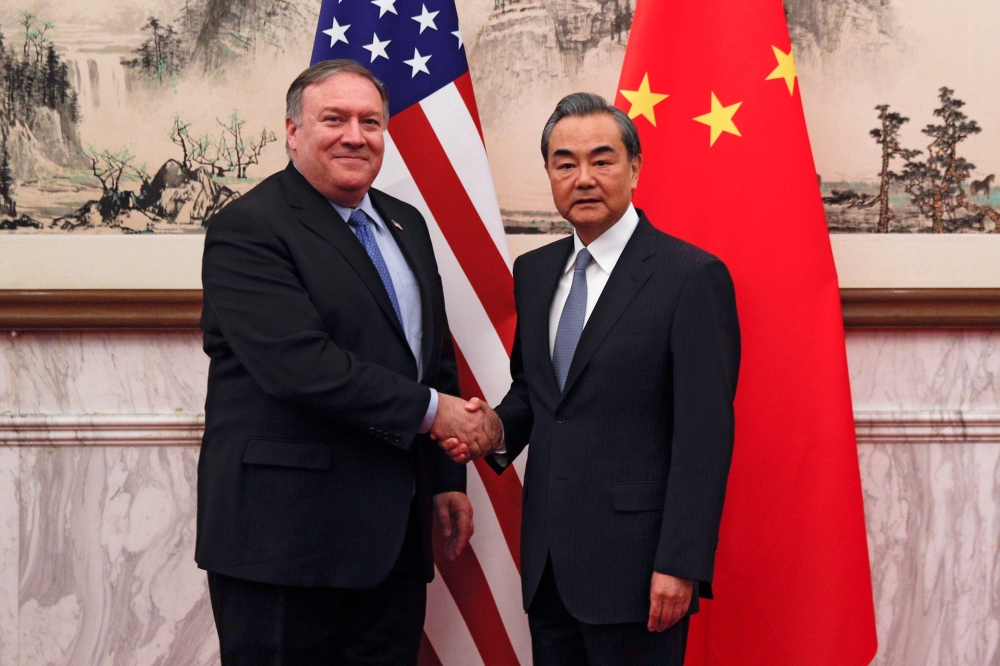 US Secretary of State Mike Pompeo (L) shakes hands with China's Foreign Minister Wang Yi (R) before they proceed to their meeting at the Diaoyutai State Guesthouse in Beijing on October 8, 2018. / AFP / POOL / Andy Wong 