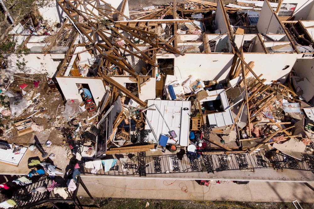 A man works though the remains of an apartment in the aftermath of Hurricane Michael October 11, 2018 in Panama City, Florida.  AFP / Brendan Smialowski
 