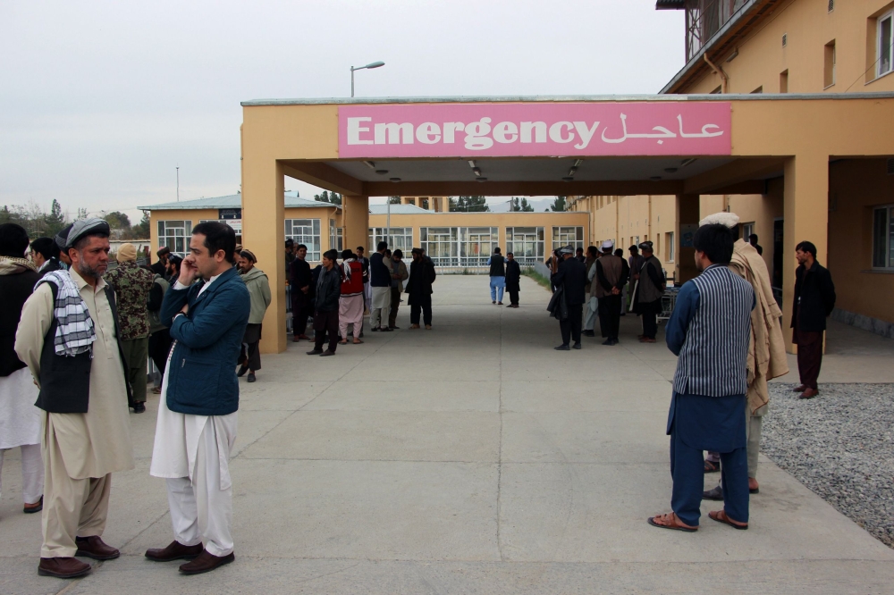 Afghan relatives of victims looks on as they stand in front of a hospital following a bomb attack in Taloqan in northeastern Takhar province on October 13, 2018. AFP / NASEER SADEQ