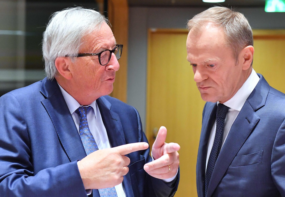 European Commission President Jean-Claude Juncker (L) and European Council President Donald Tusk greet each others at the start of a tripartite social summit at the European Council in Brussels on October 16, 2018. AFP/Emmanuel Dunand 