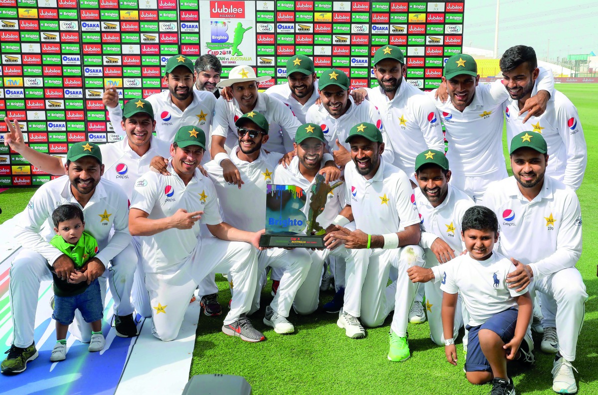 Pakistan's cricket team celebrates at the end of day four of the second Test match between Australia and Pakistan at Sheikh Zayed stadium in Abu Dhabi on October 19, 2018.  AFP / Karim Sahib

