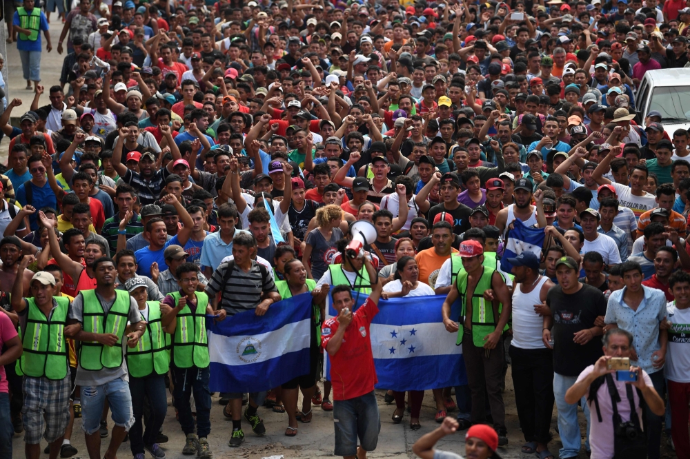 Honduran migrants heading in a caravan to the US, hold a demonstration demanding authorities to allow the rest of the group to cross, in Ciudad Hidalgo, Chiapas state, Mexico after crossing from Guatemala, on October 20, 2018. AFP / Pedro Pardo
