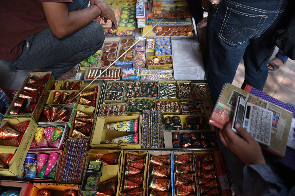 Indian customers visit a firecracker shop in New Delhi on October 23, 2018. / AFP / Money SHARMA 