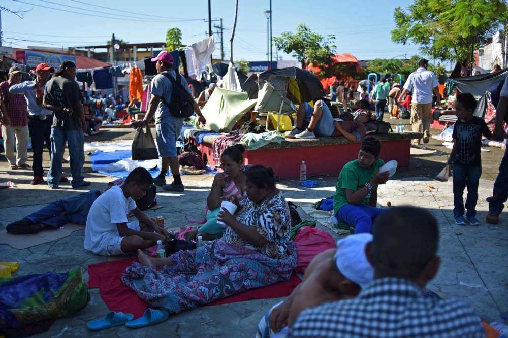 Honduran migrants taking part in a caravan heading to the US, rest in a square during a stop in their journey, in Huixtla, Chiapas state, Mexico, on October 23, 2018. / AFP / Johan ORDONEZ